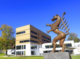 Exterior view of the Steiermarkhof with sculpture of the Styrian panther in the foreground.