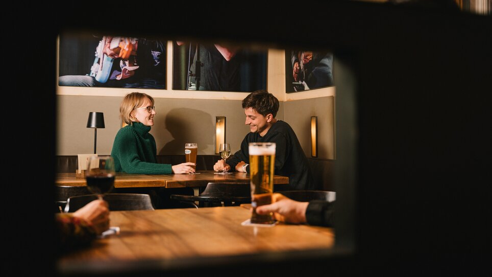 Paar an einem Tisch im Café Stockwerk mit Bier und Wein. | © G. Obetzhofer