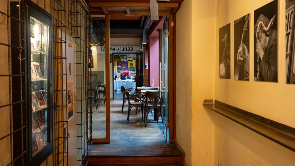 Blick in den Raum eines Jazz-Cafés mit Fotos an der Wand. | © N. Popp