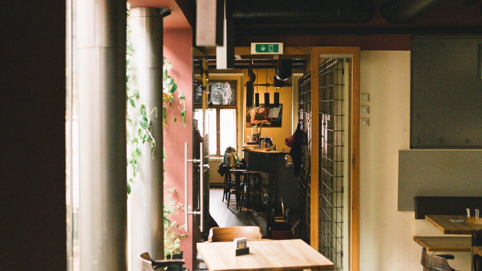 Innenansicht des Café Stockwerk in Graz - Jazzlokal mit Holztischen und Pflanzen. | © G. Obetzhofer