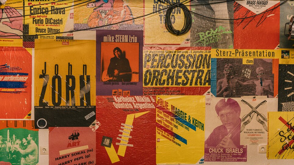 Vielzahl farbiger Plakate und Flyer an einer Wand. | © N. Popp