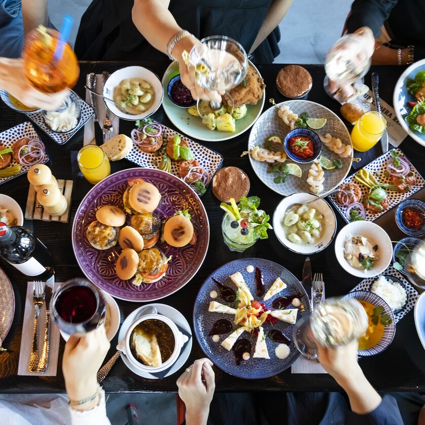 Lebhafte Tafel mit vielfältigen Speisen und Getränken.