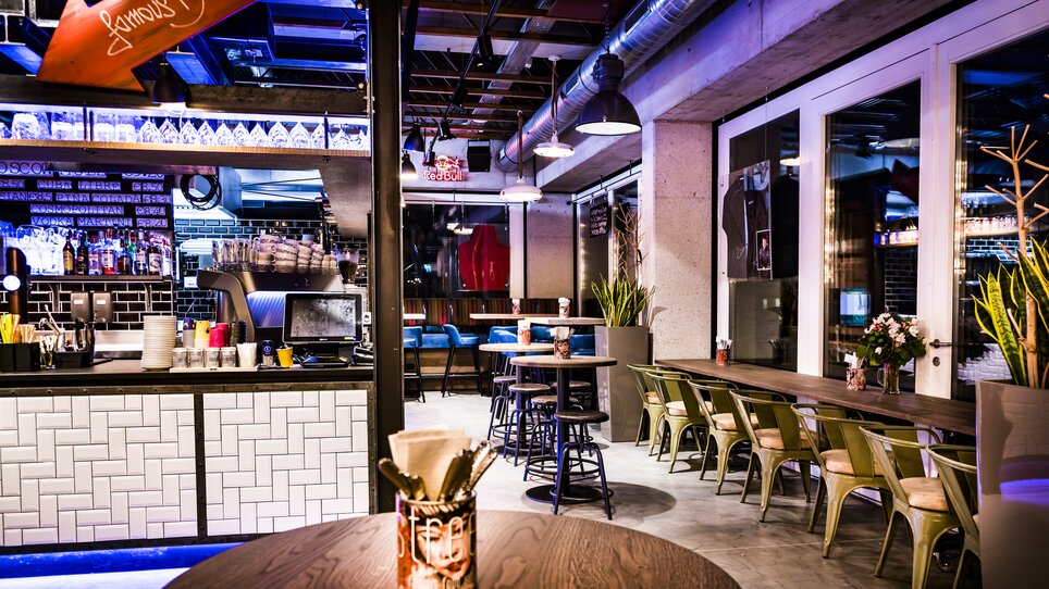 Modern restaurant interior featuring a bar and seating areas.