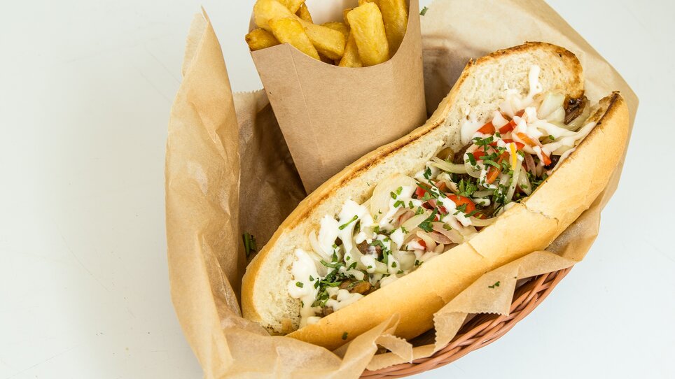 A sandwich-like meal with fried potatoes in a basket presentation. | © The Hungry Heart