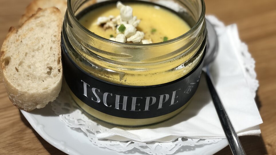 A creamy soup in a glass with bread, popcorn, and a spoon. | © Tscheppe ums Eck