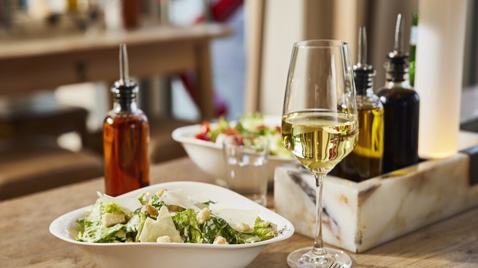 Frischer Salat und Wein auf einem Tisch im VAPIANO Graz. | © VAPIANO Global
