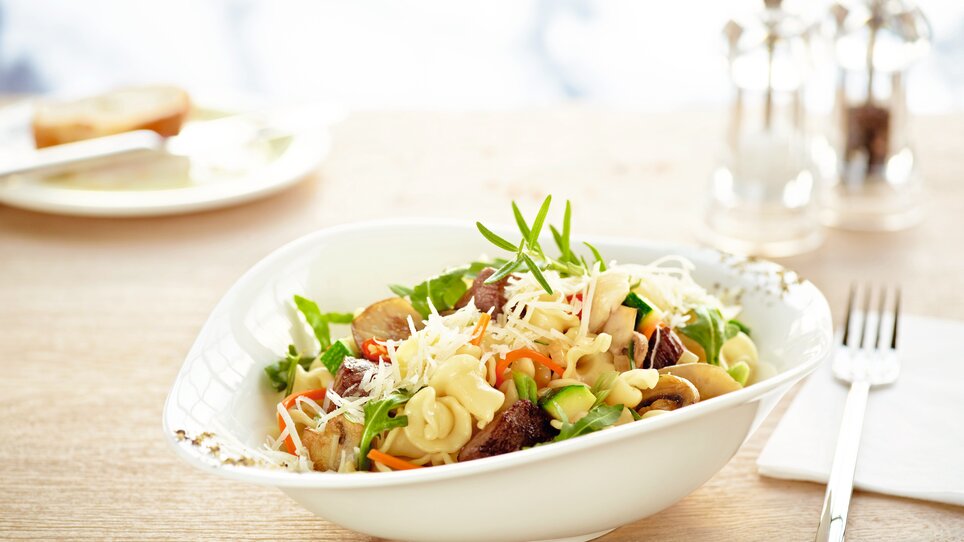 Eine Schüssel mit Pasta, Gemüse und Käse auf einem Tisch. | © Vapiano
