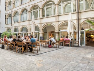 Gemütliche Weinbar im Innenhof mit Gästen in Graz. | © Klapotetz