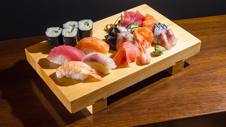 Variety of sushi and sashimi on a wooden platter. | © Yamamoto