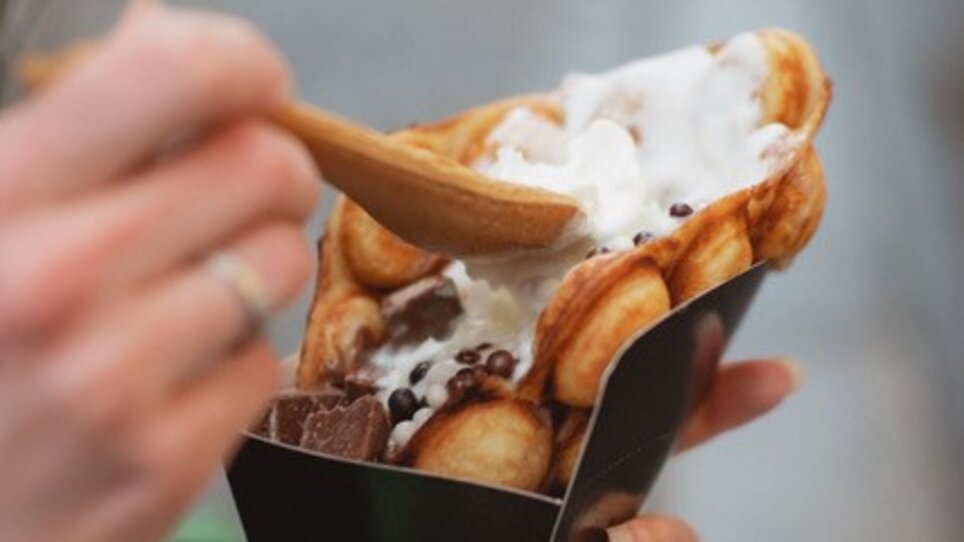 A hand holds a waffle with ice cream, in Graz. | © hepac tourism GmbH