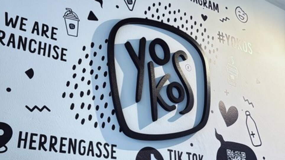 YOKOS logo on a wall with social media icons and text | © hepac tourism GmbH