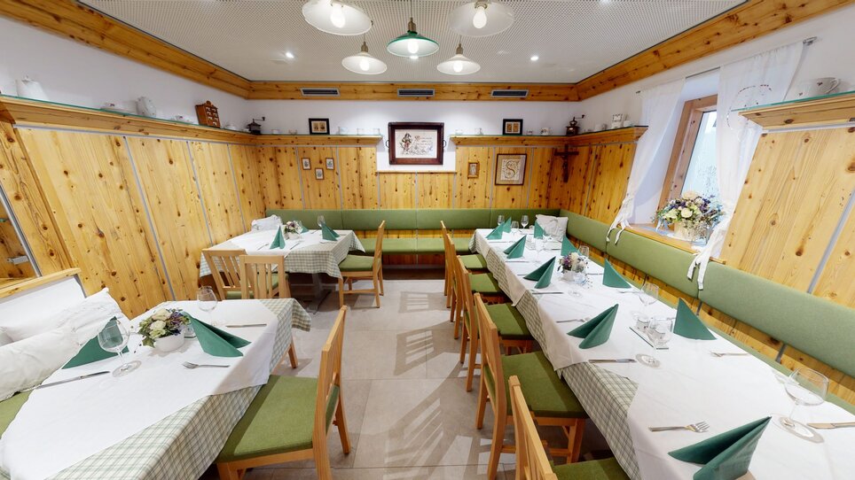 Gemütlicher Gastraum mit Holzwänden und gedeckten Tischen. | © 3D Blick