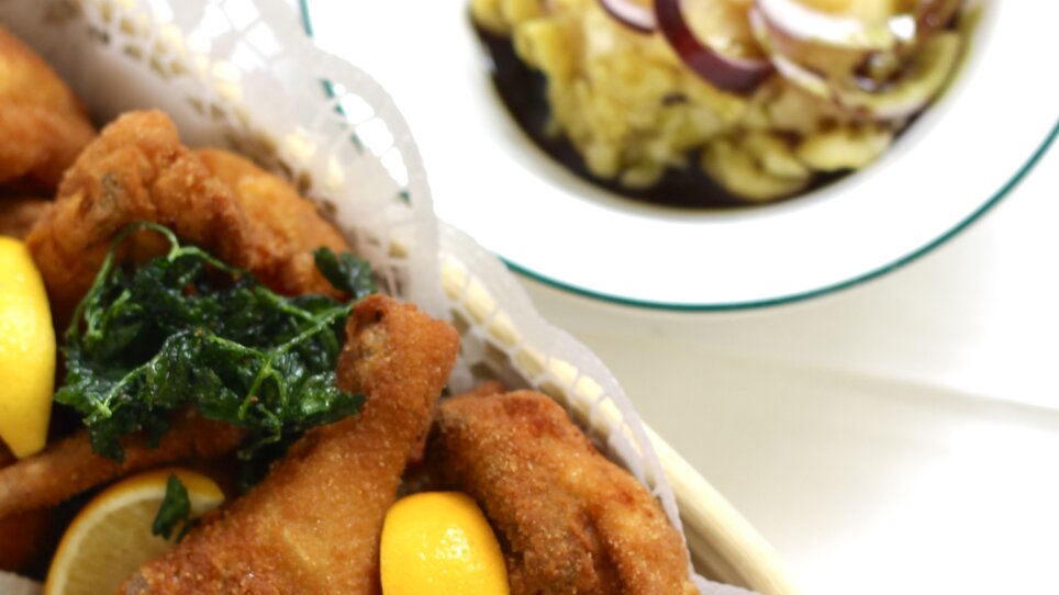 Frittierte Hähnchenstücke mit Zitrone und Salat, serviert mit Beilage. | © Gasthaus Zur Schmiedn