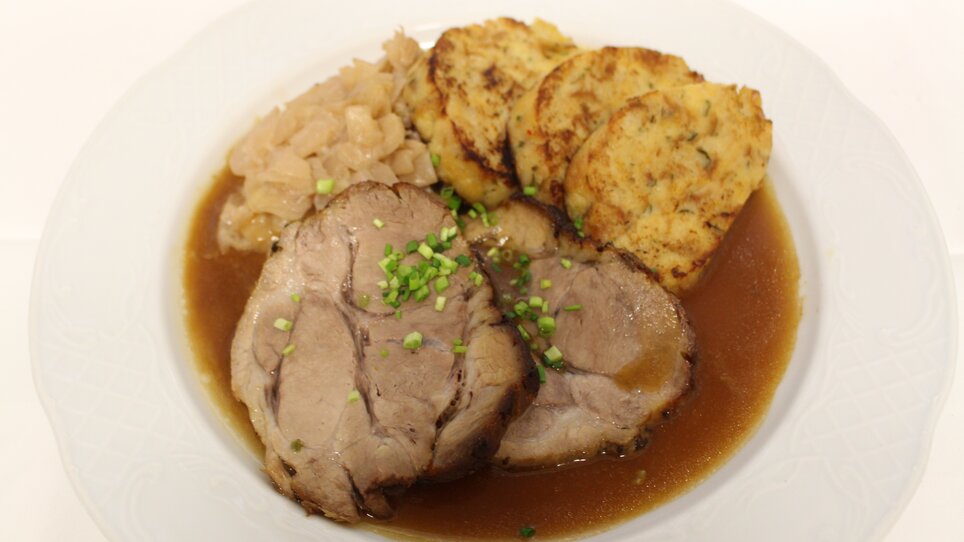 Roast pork, sauerkraut and dumplings on a plate. | © Zur alten Press