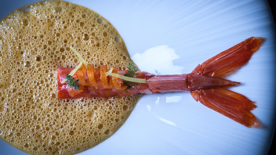 Ein kunstvolles Gericht mit Garnele und Schaum auf einem weißen Teller. | © Jürgen Schmücking
