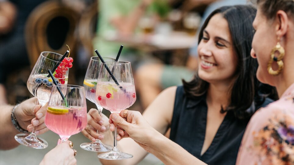 Amici brindano con cocktail colorati. | © Graz Tourismus - Mias Photoart-18