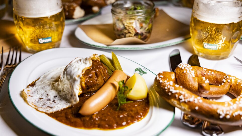Traditionelles Gericht mit Wurst, Kartoffel, Brezel und Bier in Graz. | © Graz Tourismus - Werner Krug