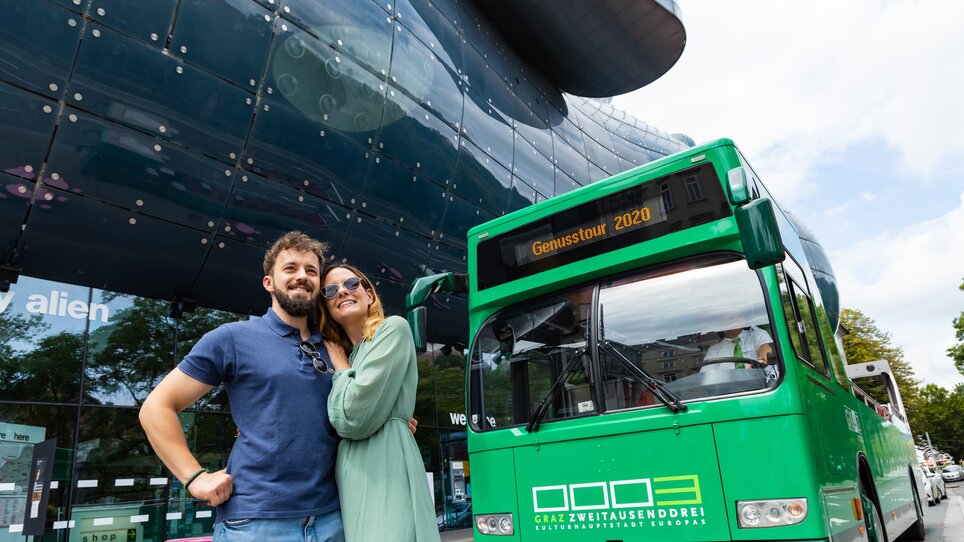 Paar vor dem Bus bei der kulinarischen Stadtrundfahrt in Graz. | © Graz Tourismus - Werner Krug