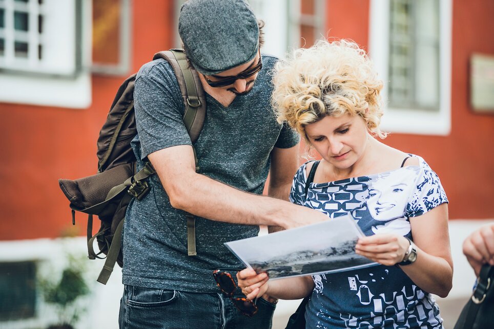 Two people examining an old photograph in Graz. | © Graz Tourismus - Lupi Spuma