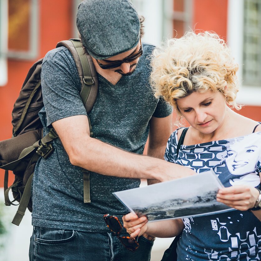 Two people examining an old photograph in Graz. | © Graz Tourismus - Lupi Spuma