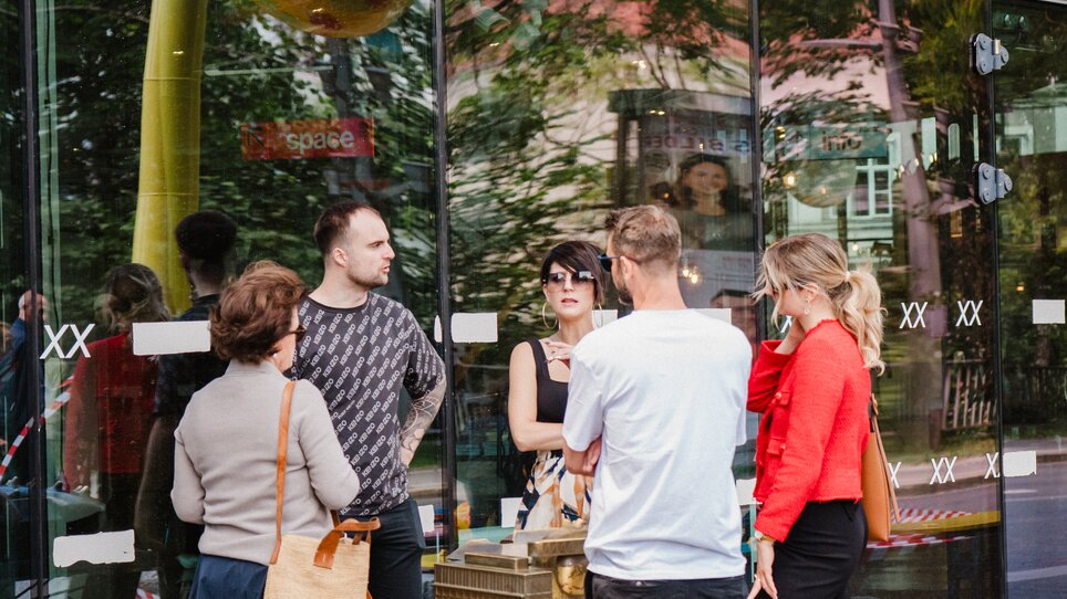 Eine Gruppe von Personen steht vor dem Kunsthaus Graz bei einem geführten Stadtrundgang. | © 5komma5sinne - MotionAds