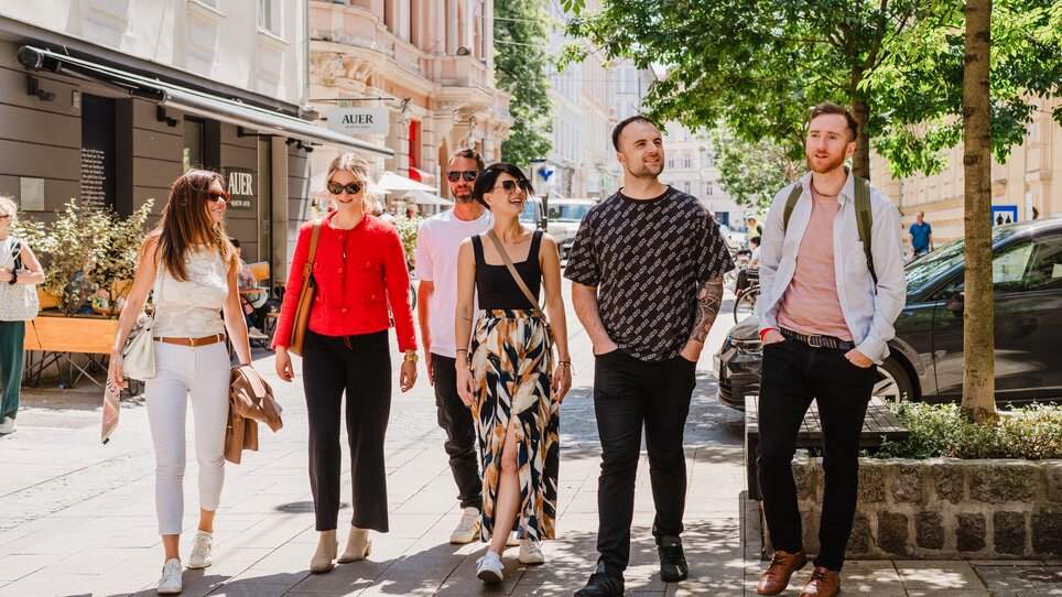 Six people enjoying a sunny day in Graz while strolling. | © 5komma5sinne - MotionAds