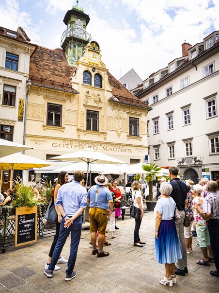Culinary tour in Graz | © Graz Tourismus - Werner Krug Group of visitors in front of the Glockenspiel at the Glockenspielplatz in Graz. | © Graz Tourismus - Werner Krug