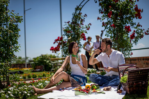 Ein Paar genießt ein Picknick mit frischen Früchten und Getränken im Freien. | © Graz Tourismus - Tom Lamm