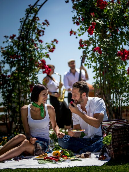 Two people enjoying a picnic with music in Graz. | © Graz Tourismus - Tom Lamm