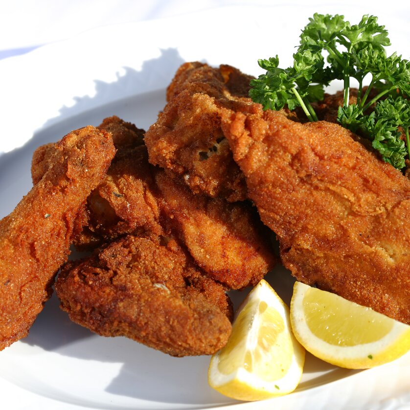 Leckere, knusprige frittierte Hühnchenstücke mit Zitronen und Petersilie. | © Graz Tourismus - Harry Schiffer