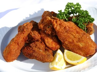 Delicious crispy fried chicken pieces with lemon and parsley. | © Graz Tourismus - Harry Schiffer
