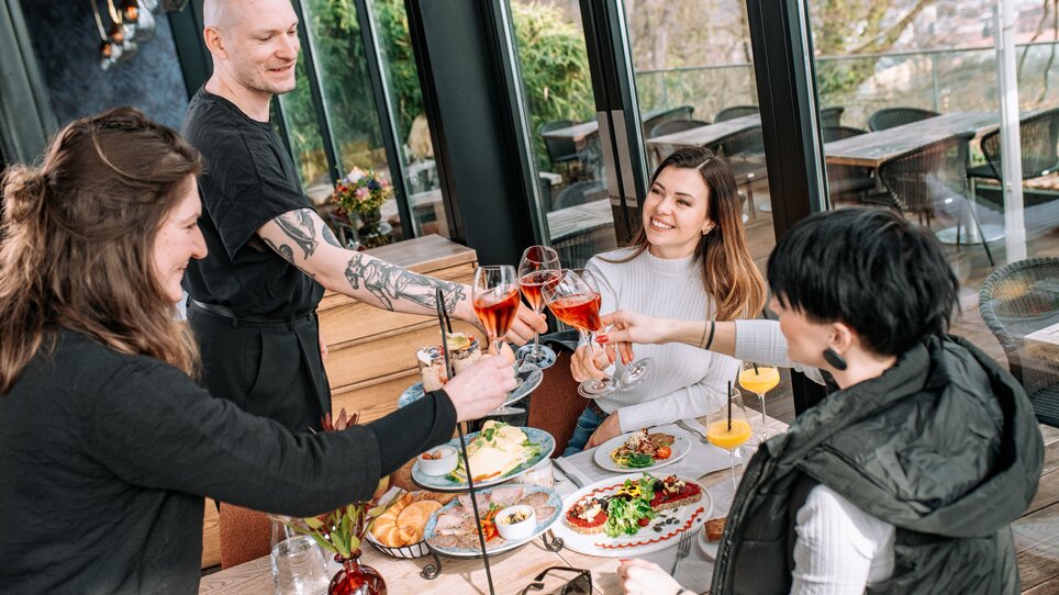 Amici brindano con drink all'aiola upstairs. | © 5komma5sinne - Rene Strasser Fotografie 