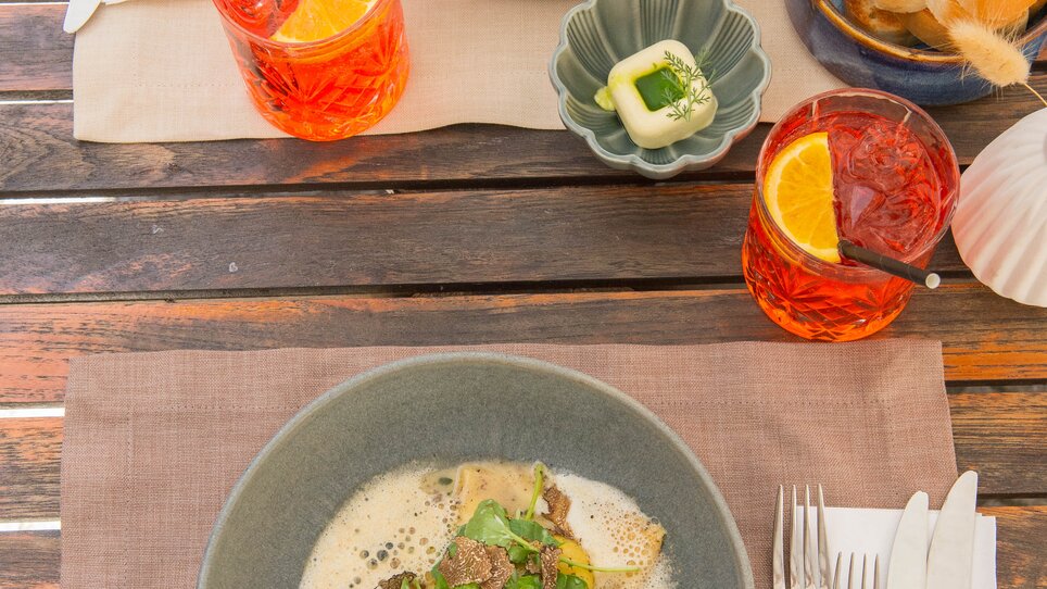 Ein exquisit angerichtetes Gericht und Getränke bei dreizehn by Gauster. | © 5komma5sinne - Helmut Schweighofer