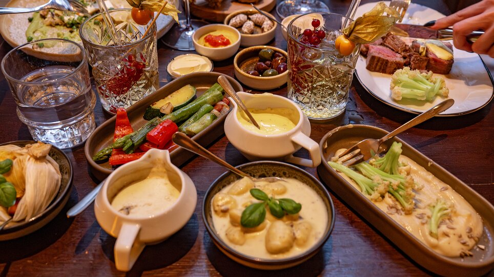 Vielfältige Gerichte und Getränke auf einem Tisch im Restaurant. | © 5komma5sinne - Rene Strasser Fotografie 