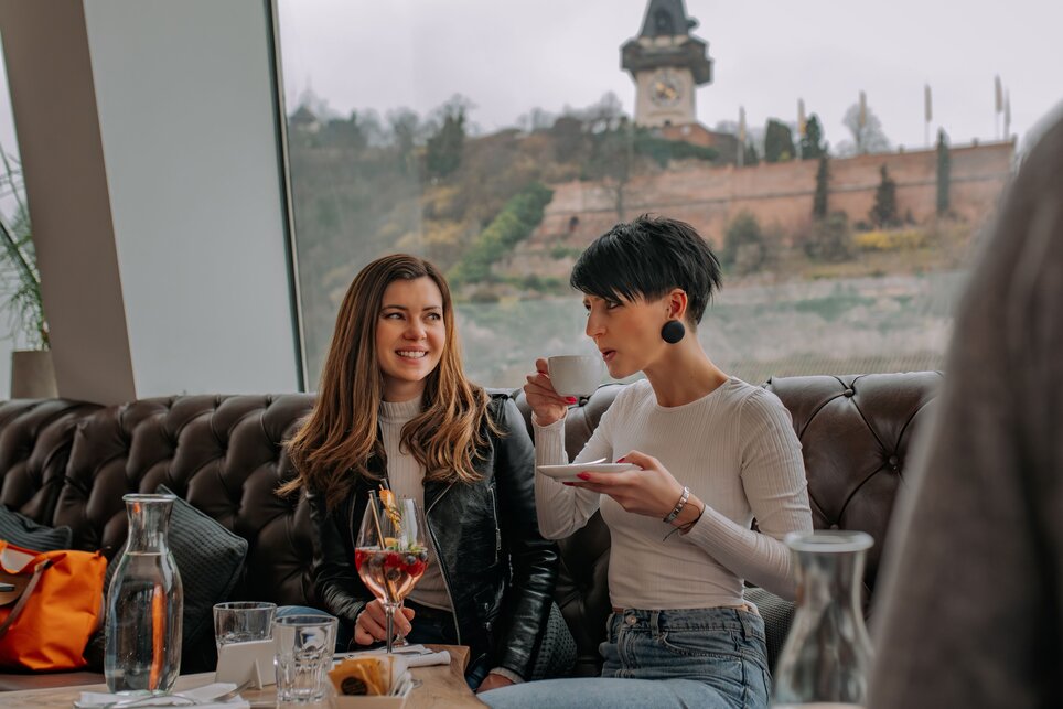 Zwei Frauen im Tagescafé Freiblick in Graz mit Graz Uhrturm im Hintergrund. | © 5komma5sinne - Rene Strasser Fotografie 