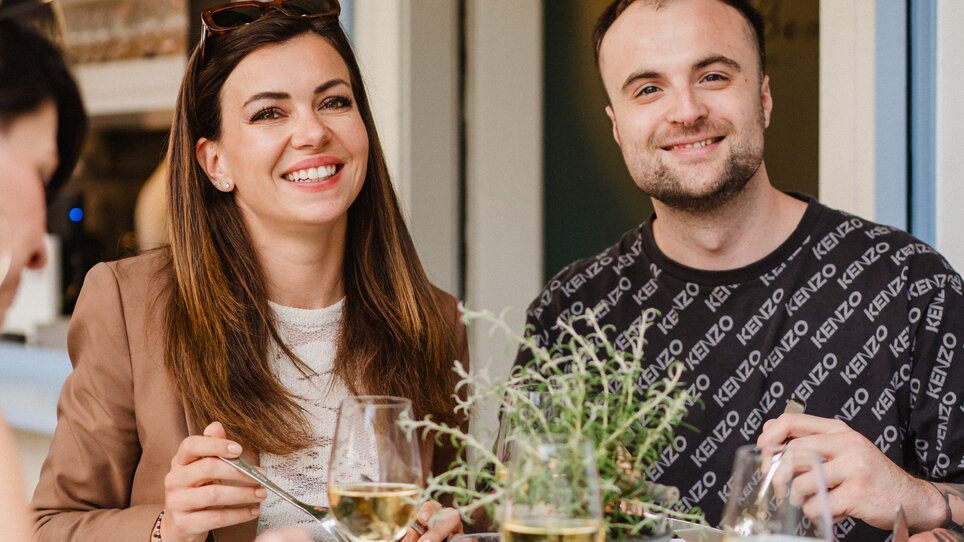 Freundliches Paar bei einem Essen am Tisch mit Weingläsern. | © 5komma5sinne - MotionAds