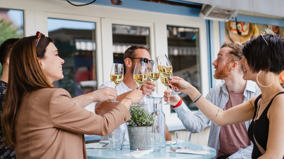 Freunde stoßen mit Gläsern auf einer Terrasse in Graz an. | © 5komma5sinne - MotionAds