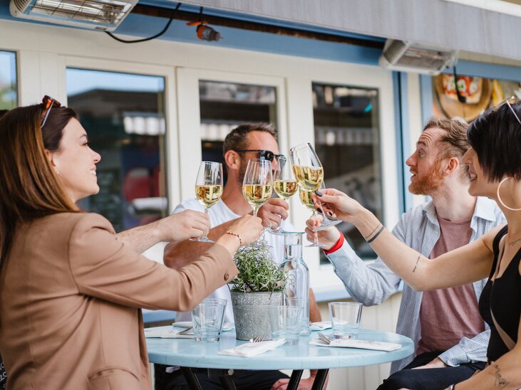 Freunde stoßen mit Gläsern auf einer Terrasse in Graz an. | © 5komma5sinne - MotionAds