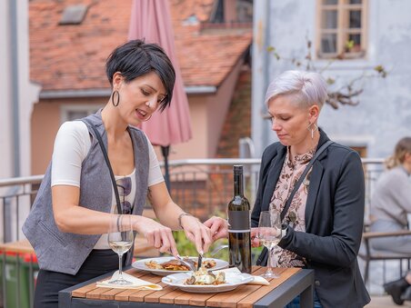 Zwei Frauen genießen das Essen und Wein im Freien bei Gut Schlossberg in Graz. | © 5komma5sinne - Rene Strasser Fotografie