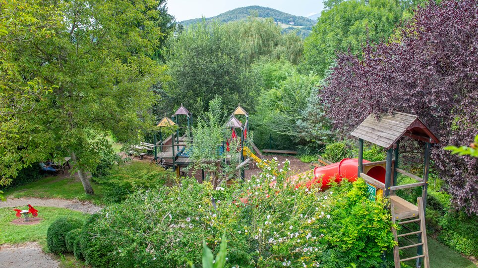 Spielplatz mit Rutschen und Spielgeräten, umgeben von Bäumen. | © 5komma5sinne - Helmut Schweighofer