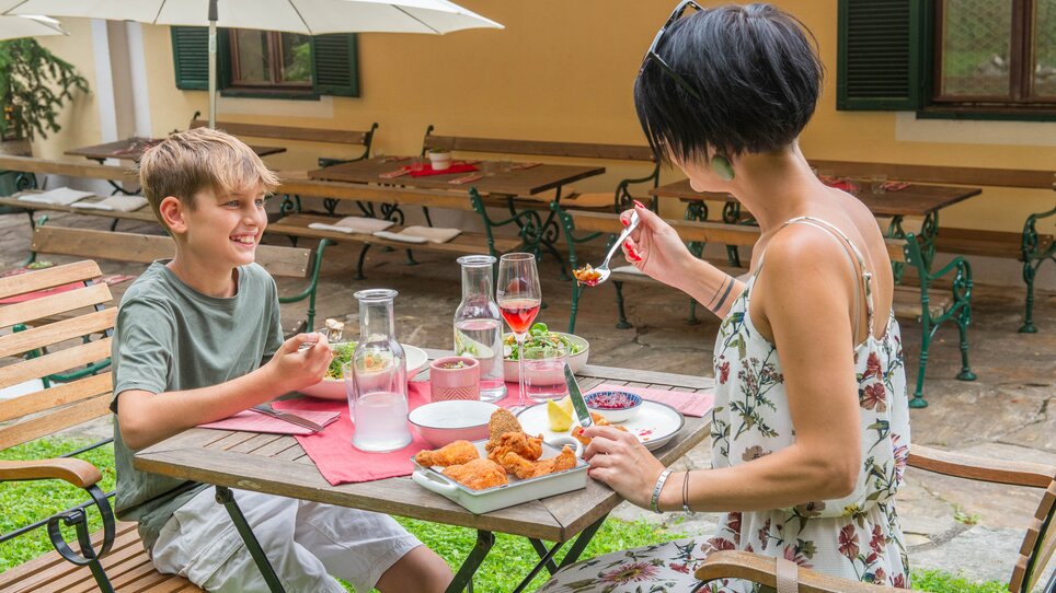 A boy and a woman enjoy a meal at Kreuzwirt am Rosenberg in Graz. | © 5komma5sinne - Helmut Schweighofer