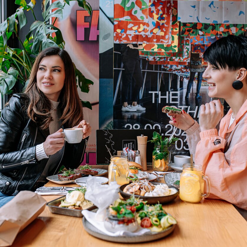 Two women at Kunsthauscafé in Graz enjoying food and drinks. | © 5komma5sinne - Rene Strasser Fotografie 