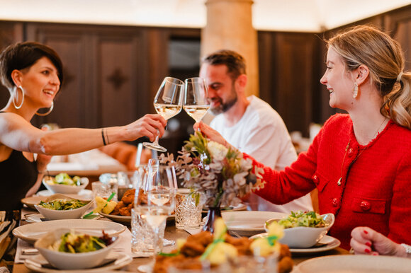 Friends on a culinary tour in the Landhauskeller in Graz, with drinks and food at the table. | © 5komma5sinne - MotionAds