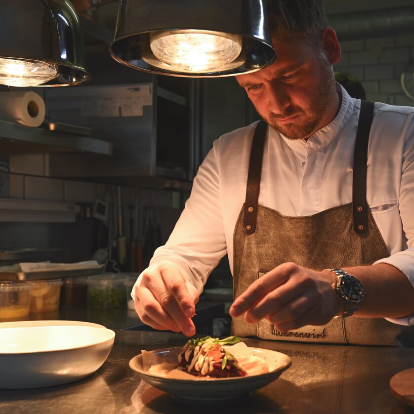 Ein Koch verfeinert eine Speise im Restaurant Mohrenwirt in Graz. | © 5komma5sinne - Rene Strasser Fotografie 