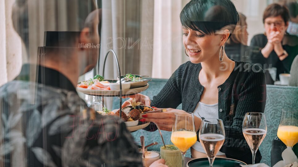 Piacere al Café Promenade in Graz | © 5komma5sinne - Rene Strasser Fotografie  Due persone che gustano cibo e bevande al Café Promenade di Graz. | © 5komma5sinne - Rene Strasser Fotografie