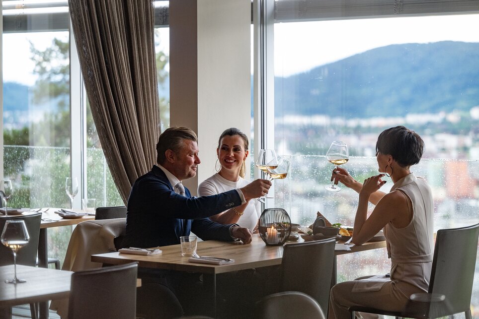 Drei Personen stoßen im Schlossberg Restaurant in Graz an. | © 5komma5sinne - Rene Strasser Fotografie 