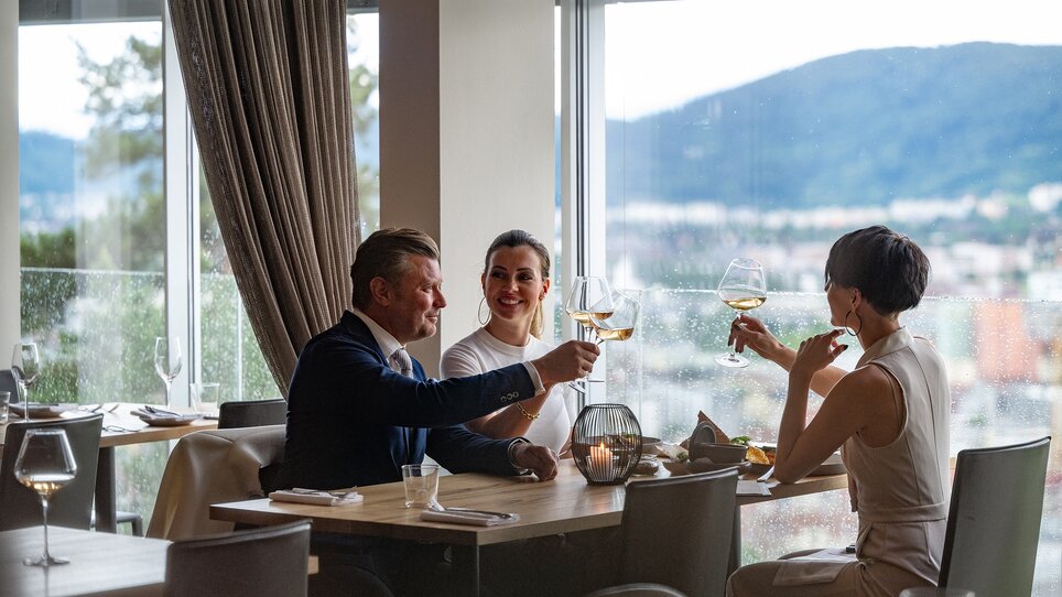 Drei Personen stoßen im Schlossberg Restaurant in Graz an. | © 5komma5sinne - Rene Strasser Fotografie 