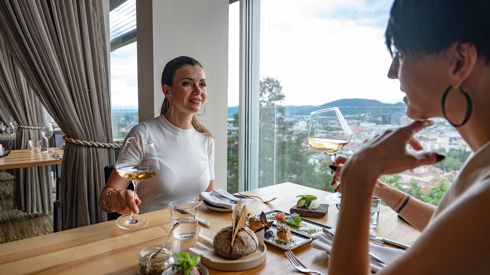 Zwei Frauen genießen Essen und Wein im Schlossberg Restaurant in Graz. | © 5komma5sinne - Rene Strasser Fotografie