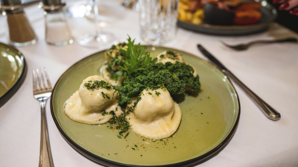 Fagottini ripieni alle erbe su un piatto verde. | © 5komma5sinne - Rene Strasser Fotografie 