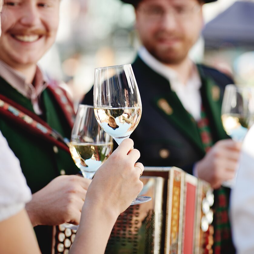 Personen mit Weingläsern und einem Akkordeon. Festliche Stimmung. | © BIO AUSTRIA Steiermark - Königshofer